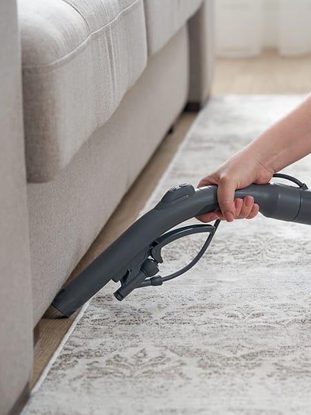 Household and housework hoovering under sofa